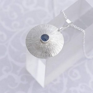round silver pendant with sapphire in the centre by iana Jewellery